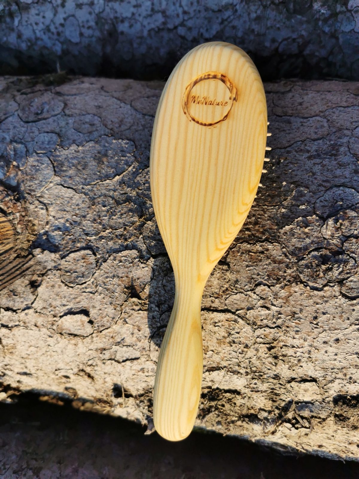 Haarbürste mit Holzstiften auf Baumstamm